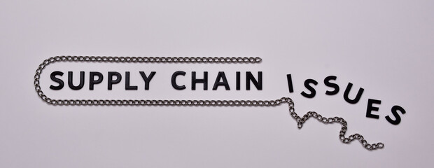 Supply Chain issues concept. Black letters with steel chain.