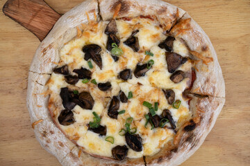 Mushrooms pizza. Top view of a pizza with provolone and mozzarella cheese, tomato sauce and champignons.