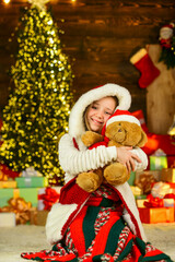 Best wishes. morning before Xmas. Cute little girl with gifts. Kid enjoy the holiday. winter holiday and vacation. Portrait kid with gift. free time and joy. kid in santa costume at christmas present