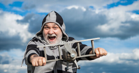 caucasian senior man on sky background. senior man at retirement. senior retired man with toy plane