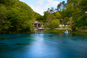 A picturesque view of the reservoir in front of an abandoned railway station drowning in greenery. Railway station Pysyrtskha, New Athos, Abkhazia.