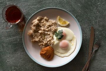 Healthy breakfast oatmeal and fried eggs on a large platter, top view, healthy eating