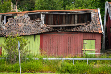 Old red barn with a collapsed roof.