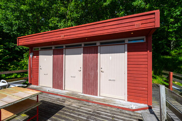 Exterior of a sauna by a lake.