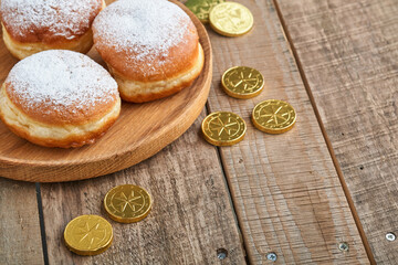 Happy Hanukkah. Hanukkah sweet doughnuts, gift boxes, white candles and chocolate coins on old  wooden background. Image and concept of jewish holiday Hanukkah. Top view.