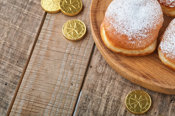 Happy Hanukkah. Hanukkah sweet doughnuts, gift boxes, white candles and chocolate coins on old  wooden background. Image and concept of jewish holiday Hanukkah. Top view.