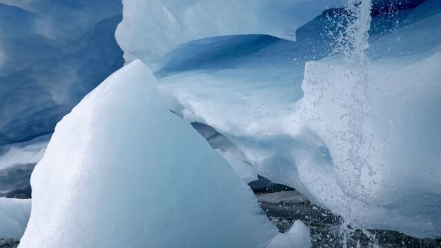 Blue white ice of glacier inside of ice cave. Glacier melting down and water is flowing out from it. Global warming, climate change, melting glaciers concept