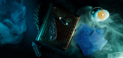 Mystical book of magic and tarot cards for divination on a dark table. Panoramic mockup for your logo. Horizontal banner with copy space for popular social media website cover image. - obrazy, fototapety, plakaty