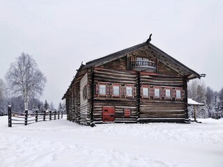 Old wooden house in traditional russian northern village in winter day. Malye Korely, Arkhangelsk region. 