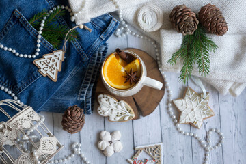 Hot tea with orange, sweets and decorations for the new year.