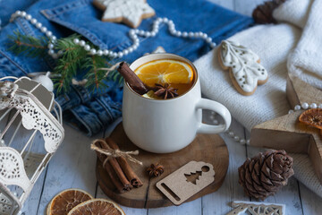 Hot tea with orange, sweets and decorations for the new year.