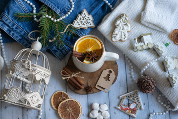Hot tea with orange, sweets and decorations for the new year.