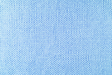 Close up background of knitted wool fabric made of viscose yarn. Pastel blue color wool knitwear texture. Abstract knitted jersey background. Fabric abstract backdrop, wallpaper
