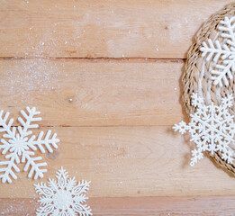 white snowflake ornaments on wooden ground with space for text