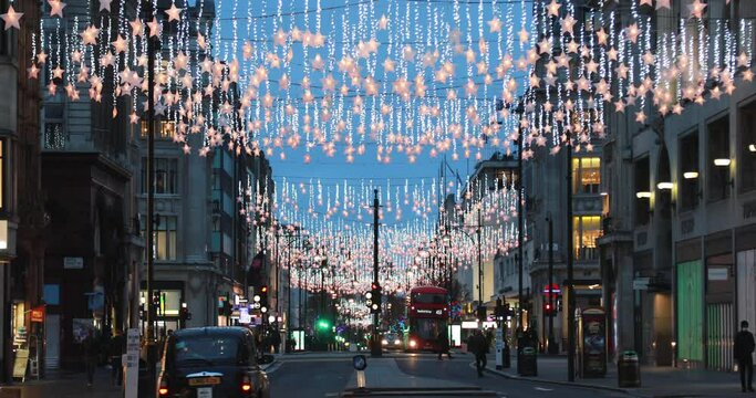 View of a colorful decorated festive Christmas decoration and holiday lights at night in Oxford Circus in Central London, England, UK