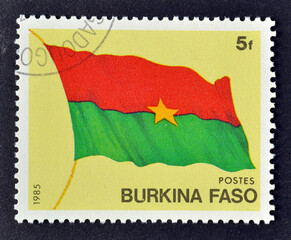 Cancelled postage stamp printed by Burkina Faso, that shows Flag of Burkina Faso, circa 1985.