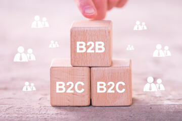 Businessman hand arranging wood block with B2B business to business and B2C Business to Customers Concept.