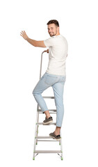 Young man climbing up metal ladder on white background