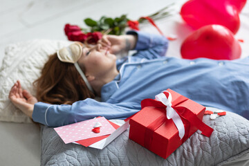 Beautiful smiling young woman at home with a red gift box on Saint Valentine's day. Happy day full of love. High quality photo