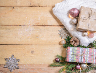 white woolen blanket with christmas gifts, christmas balls and snowflake ornaments on wooden ground with space for text