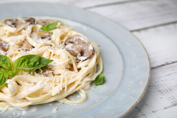 Delicious pasta with mushrooms and cheese on white wooden table, closeup