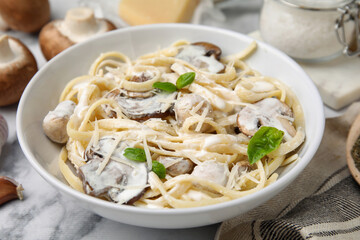 Delicious pasta with mushrooms on white marble table, closeup