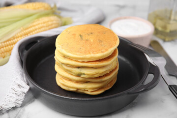 Tasty corn pancakes served on white marble table, closeup