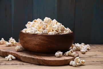 Bowl of tasty popcorn on wooden table