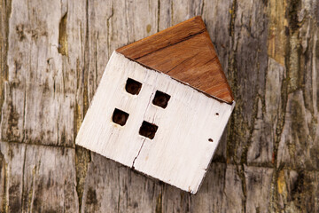 Cracked wooden house model on a grunge board