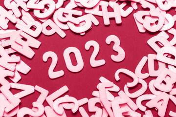 Viva Meganta toned red magenta New Year 2023 latin inscription. Heap of wooden alphabet letters...