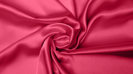 Obraz premium Viva Meganta toned red magenta fabric atlas. Close up pink silk satin texture for sewing. Abstract background wallpaper. Twisted folds cloth. Trendy color of the year 2023. Fashion color pattern