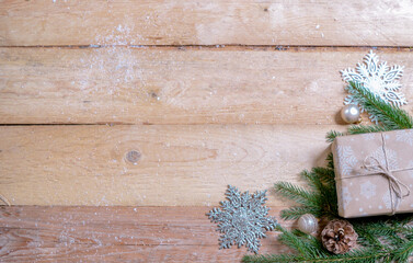 christmas gifts with fir branches, snowflake ornaments and christmas balls on wooden ground with space for text