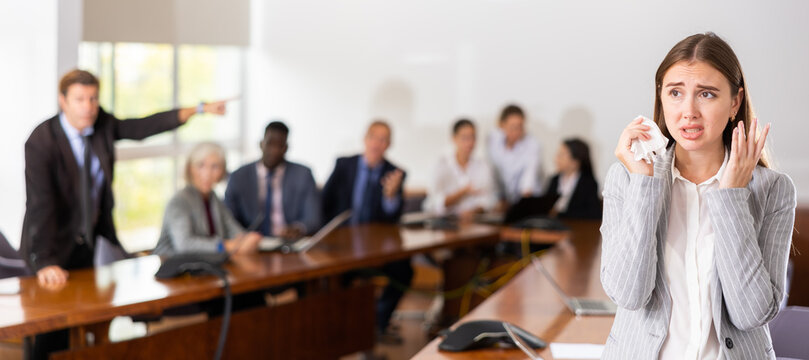 Frustrated Stressed Young White Female Office Worker With Frightened Expression On Her Face Being Fired While Angry Male Boss Scolding At Her, Pointing At Door Asking To Leave Office