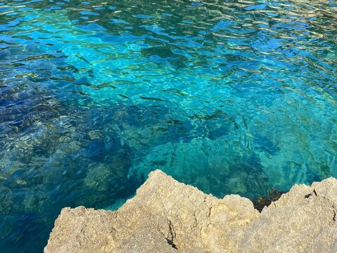 Sea turquoise blue azure water surface and coastal rocks in paradise lagoon.