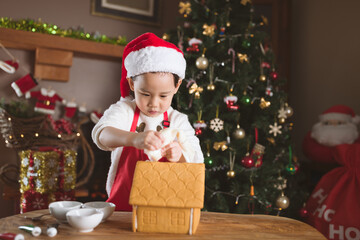 young girl making gingerbread house at home