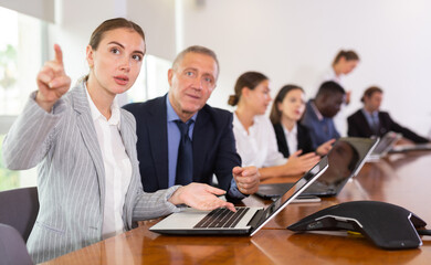 Fototapeta premium Mature businessman prompts and helps businesswoman during a business meeting