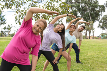 group of friends of different ages stretching arms to the side in the neighborhood park
