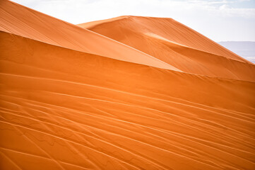Fototapeta na wymiar Sahara Desert sand dunes background. Popular travel destination, Erg Chebbi, Sahara Desert, Morocco.