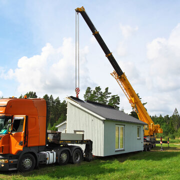 Installation Of A Modular House. House On A Car Platform. The Tractor Brought The Module.