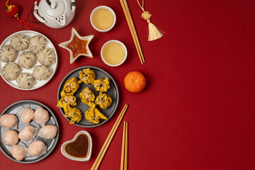 Obraz na płótnie Canvas Chinese new year festival table over red background. Traditional lunar new year food. Flat lay, top view