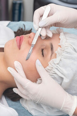 skin treatment with the dermaplaning technique performed with a scalpel by a beautician in a center of aesthetics and beauty of the body and skin