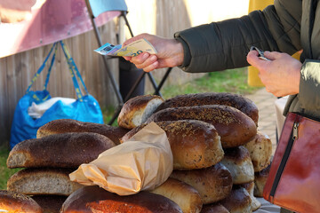 A European woman buys bread at a fair. Selective sharpness.