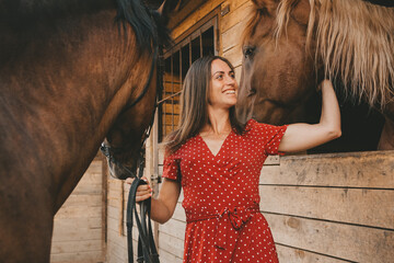  portrait of a beautiful long-haired girl and a horse in the stable