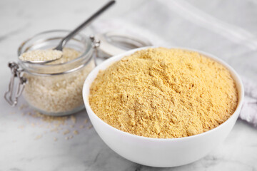 Sesame flour in ceramic bowl on white marble table