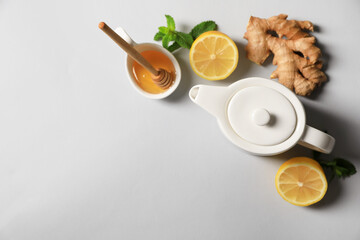 Obraz na płótnie Canvas Delicious ginger tea and ingredients on light grey background, flat lay. Space for text