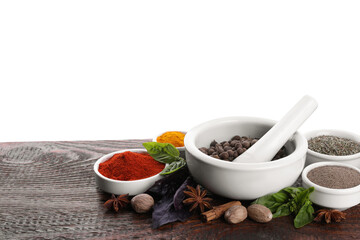 Mortar and different spices on wooden table against white background. Space for text