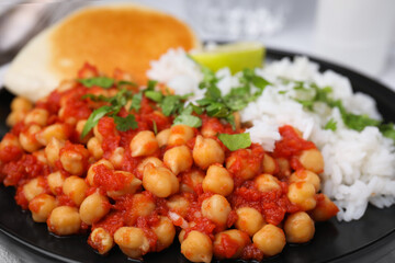 Delicious chickpea curry with rice on table, closeup