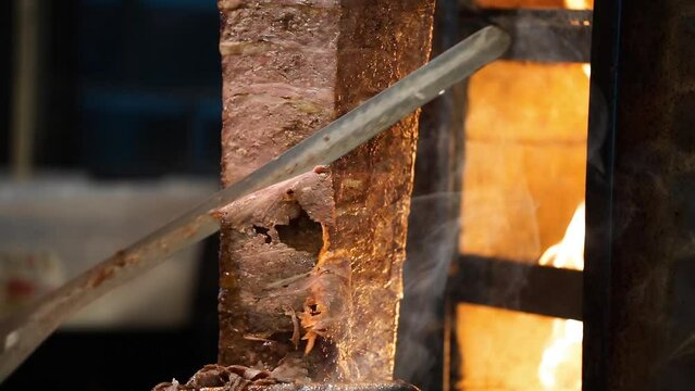 Meat doner cut close-up videos, cutting hanging doner. Turkish kebab iskender. Shawarma meat being cut before making