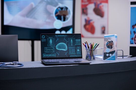 Brochures With Medical Information On Reception Desk Of Neuroscientific Clinic. CT Scan Showing Diagnosis Of Patient Disease. Objects Of Neurosurgeon Doctor On Desk In Empty Hospital With No People.