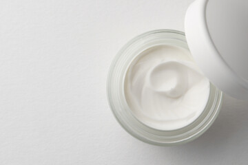 Jar of face cream on white background, top view. Space for text